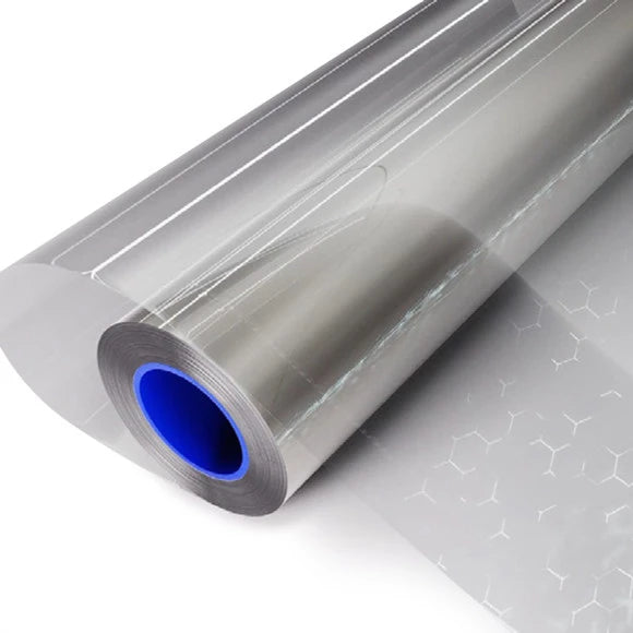A roll of clear adhesive film or vinyl wrap with a blue inner core, shown on a clean white background with a patterned sheet extending from one end.
